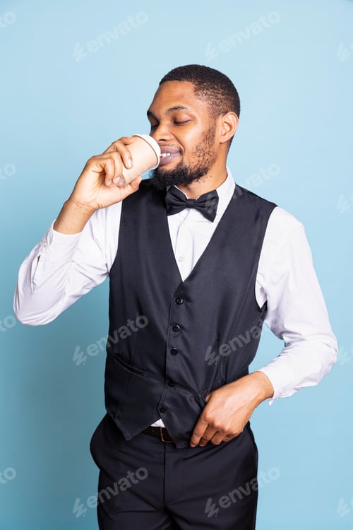 Preview: Professional hotelier drinking a cup of coffee at work in studio