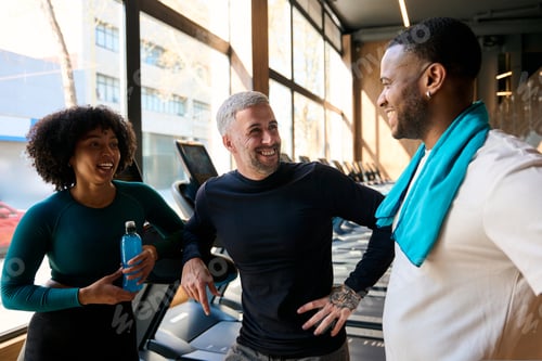 Preview: Diverse friends laughing and talking at fitness gym