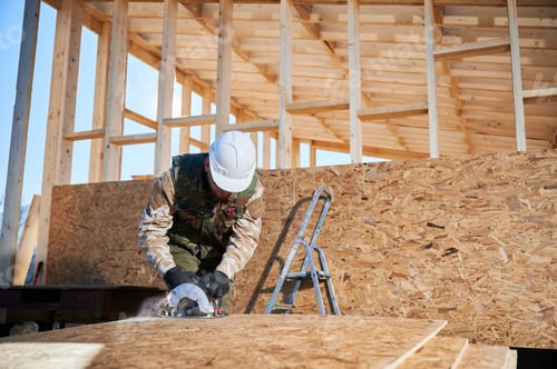 Preview: Carpenter using circular saw for cutting OSB board for building wooden frame house.