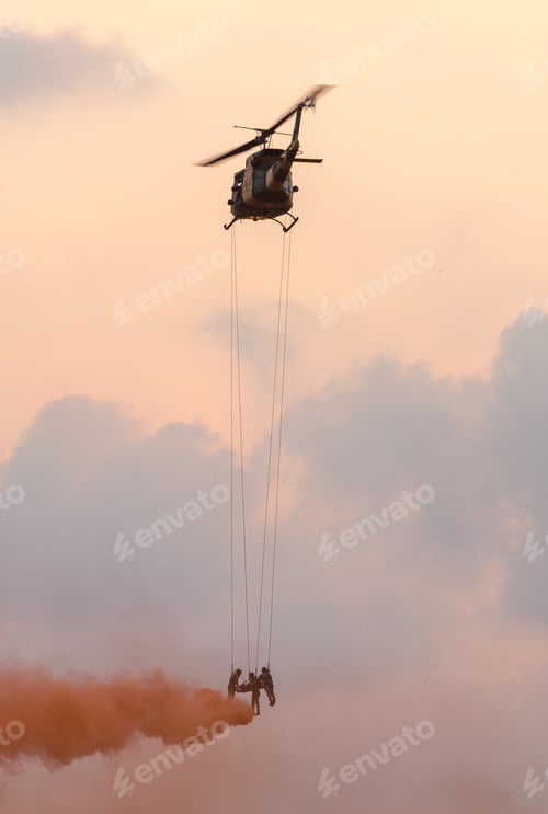 Preview: Medics airlift an injured soldier beneath a hovering helicopter using ropes and smoke cover