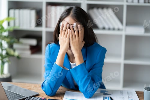 Preview: Stressed puzzled Asain businesswoman sitting in office room, burnout, overworked concept.