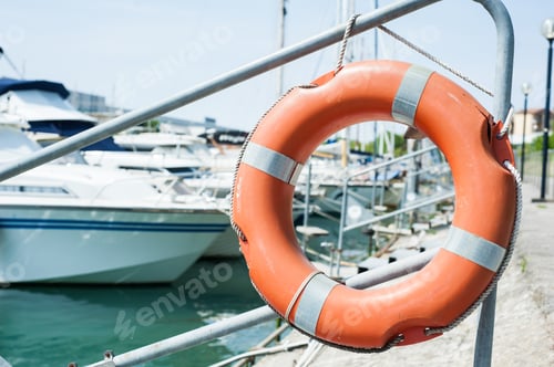 Preview: Life buoy hung on a railing in the port.