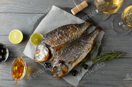 Preview: Baked Dorado on garnished wooden background, top view