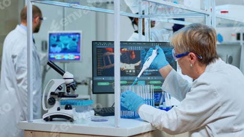 Preview: Elderly research scientist using micropipette filling test tubes