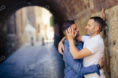 Preview: Affectionate Couple Embracing under Stone City Archway