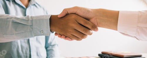 Preview: Entrepreneurs collaboration deal shaking hands in a modern office and financial paper graph on desk.