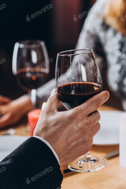 Preview: Mature couple is enjoying romantic moments together in the restaurant with glasses of red wine