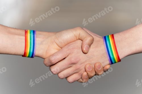 Preview: Close-up of a handshake with wristbands supporting the lgtbi movement.