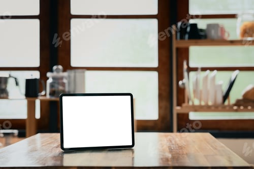 Preview: Blank screen digital tablet on wooden table in a warm kitchen.
