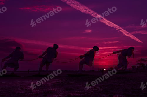 Preview: Silhouettes of statues pulling ropes at sunset