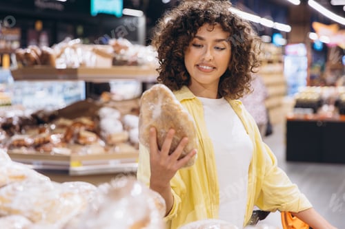 Preview: Woman choosing bread in supermarket bakery section