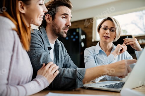 Preview: Young couple using laptop with their financial advisor while having a meeting at home.