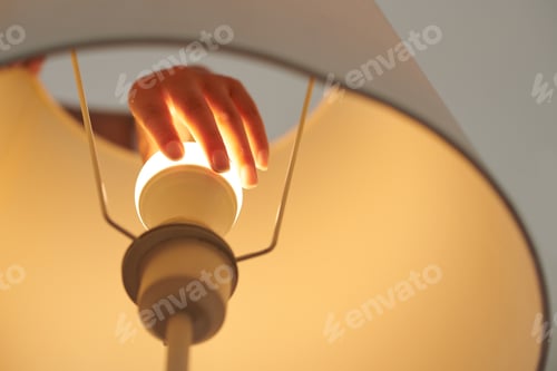 Preview: Woman changing light bulb in lamp