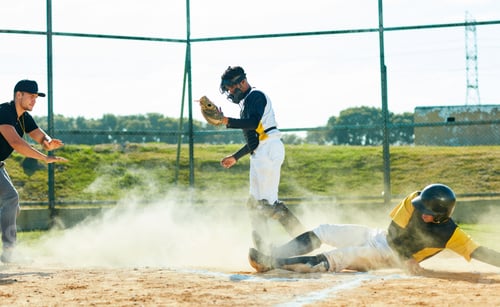 Preview: Full length shot of a young baseball player reaching base during a game on the field