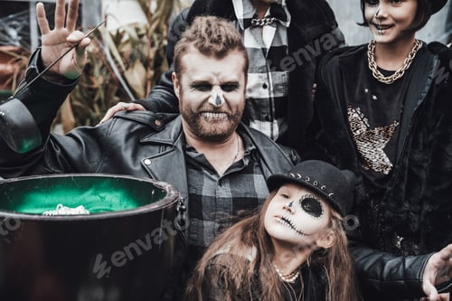 Preview: Scary family, mother, father, daughters celebrating halloween. Cauldron of potion.Terrifying black s