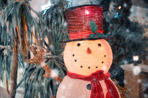 Preview: Snowman with hat and scarf in snowfall on Christmas festival