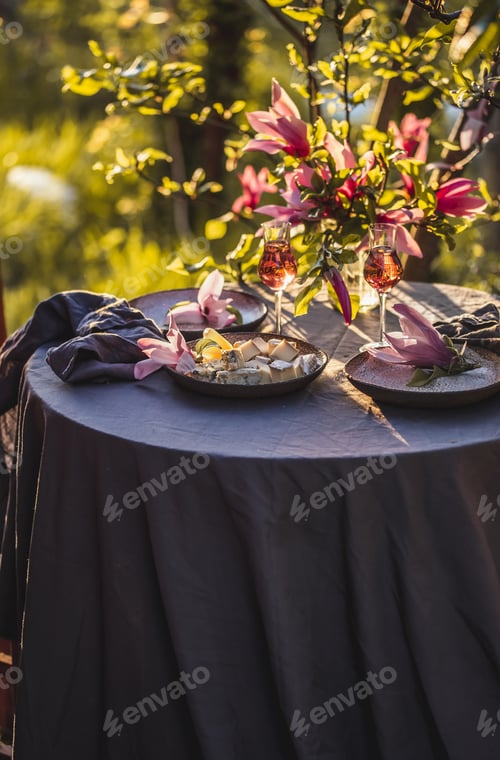 Preview: Table decorated with magnolia flowers under magnolia tree.