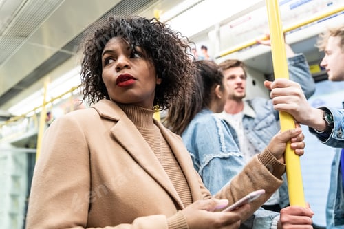 Preview: Busy tube, people commuting, black woman holding phone
