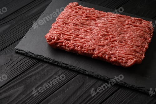 Preview: Raw mince beef, ground meat. Black background. Top view. Copy space