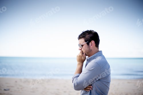 Preview: Shallow focus shot of a male wearing sunglasses and thinking