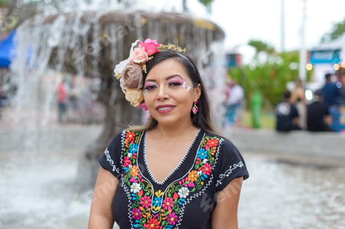 Preview: Mexican woman wearing traditional dress with multicolored embroidery celebrating independence day.