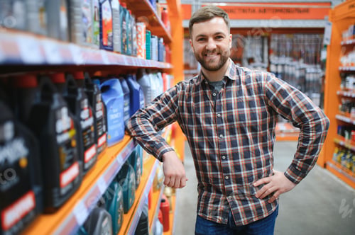 Preview: seller man with canister of motor oil in auto store