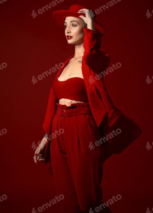 Preview: Vision, fashion and a woman in a hat on a red background in studio for elegant or trendy style. Aes