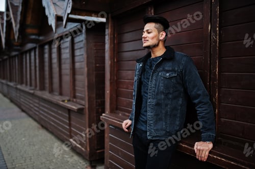 Preview: Man with hairstyle leaning against dark wooden wall