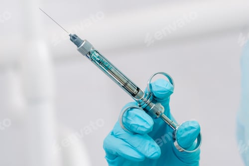 Preview: close-up of a dentist's hand holding an injection syringe for a patient in the office