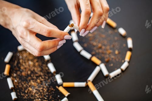 Preview: Stop smoking concept on background with broken cigarettes. Heap of cigarettes. No smoking