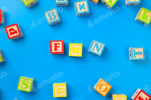 Preview: Fun. Wooden colorful alphabet blocks on blue background, flat lay, top view