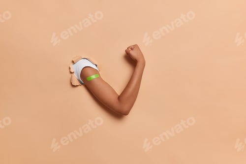 Preview: Vaccination and healthcare during covid 19 epidemic. Unrecognizable powerful human wears band aid af
