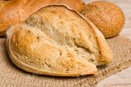 Preview: Homemade natural breads. Different kinds of fresh bread as background, perspective view