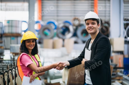 Preview: Team engineers and foreman stack hand and shake hands to show success at factory machines.