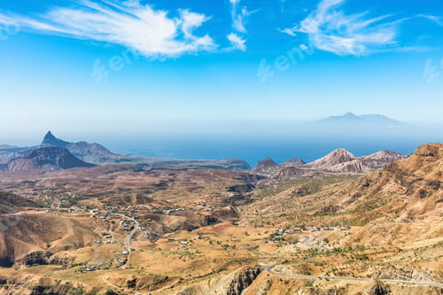 Preview: A panoramic view of rugged mountains under a clear blue sky.