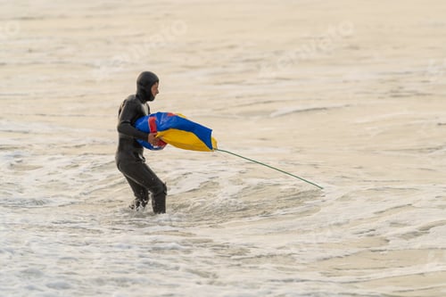 Preview: Fisherman inside water carrying a bag after fishing with net