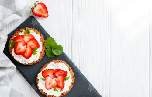 Preview: Healthy sandwich with strawberry and cream cheese on slate board.