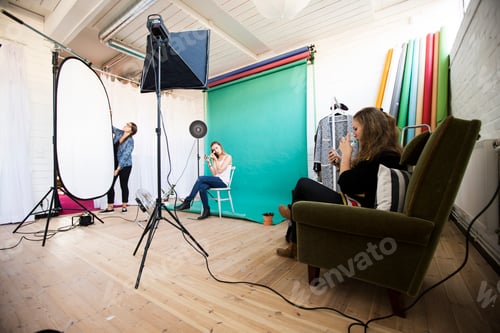 Preview: Fashion models getting dressed while assistant working in photo studio