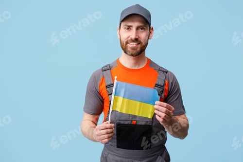 Preview: Smiling Delivery man in uniform holding ukrainian national flag in hands