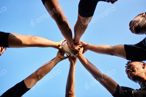 Preview: Cropped shot of a handsome group of sportsmen holding a rugby ball together before playing rugby