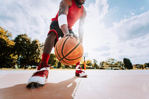 Preview: Basketball street player dribbling with ball on the court