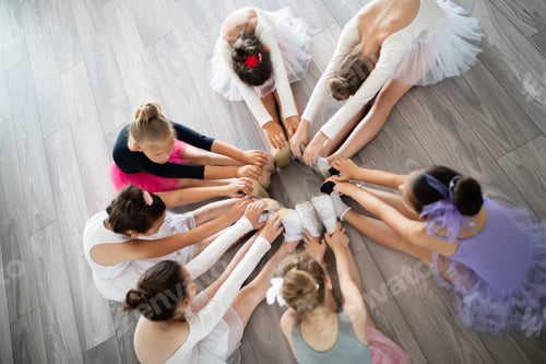 Preview: Group of fit happy children exercising ballet in studio together