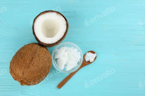 Preview: Flat lay composition with organic coconut oil on light blue wooden table. Healthy cooking