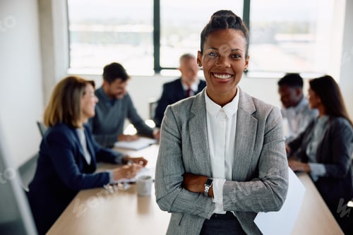 Preview: Confident black female CEO during business meeting at corporate office looking at camera.