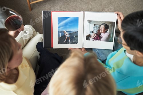 Preview: Three Young Adult Caucasian Women Viewing Photo Album and Drinking Wine Together