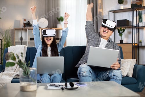 Preview: Asian family using modern laptop and VR glasses at home