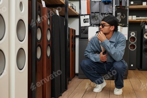 Preview: Young black man choosing professional speakers in music store