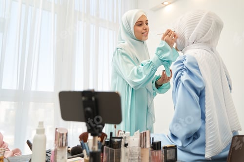 Preview: Young beautician following video instructions in her work