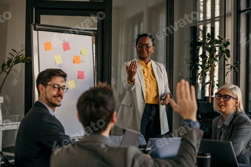 Preview: Businesswoman leading a presentation to her colleagues raising their hands to ask questions
