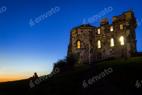 Preview: Silhouette of a person sitting near to the Gothic House in Edinburgh